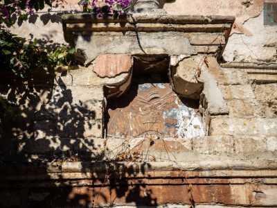 Simili decori proseguono anche sulla parte destra del cortile dove intravediamo un singolare stemma con un berretto frigio che sovrasta una bombarda contornata da lance su palle di cannone. Si tratta di un simbolo della rivoluzione francese, forse un riferimento a quando, nel 1799, il palazzo divenne il quartier generale delle truppe napoleoniche